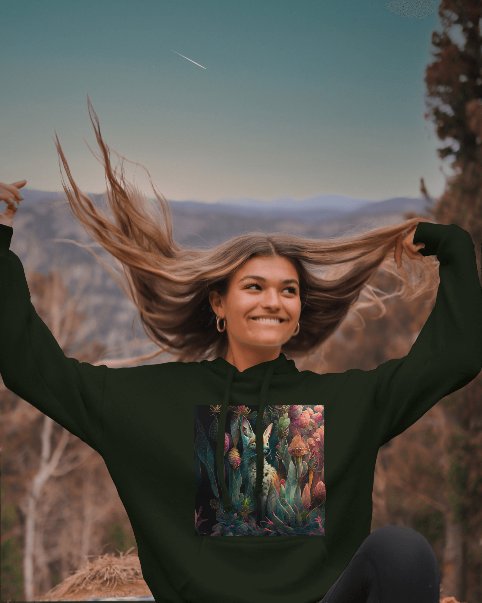 Experience nature's beauty in our stunning 'Nature's Beauty: Fox in a Meadow of Florals' pullover hoodie, available in Forest Green and Black. Seen here on a woman enjoying the outdoors, the intricate fox artwork and beautiful florals create an eye-catching design. Stay comfortable and stylish during your next outdoor adventure with this nature-inspired pullover hoodie
